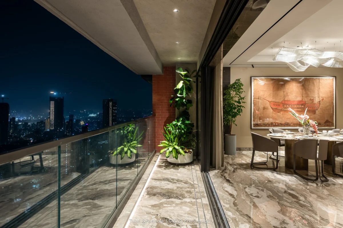 Terrace and dining room of a high-floor apartment at night above the city